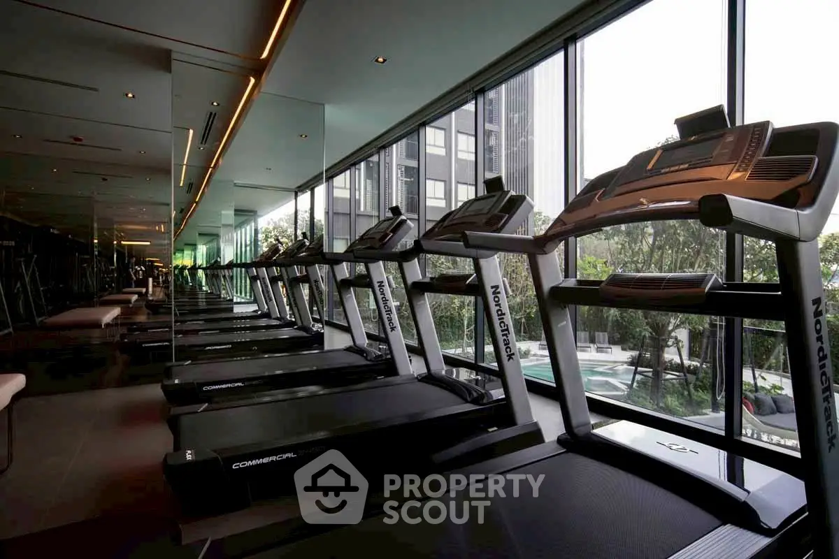 Modern gym with treadmills and large windows offering city views