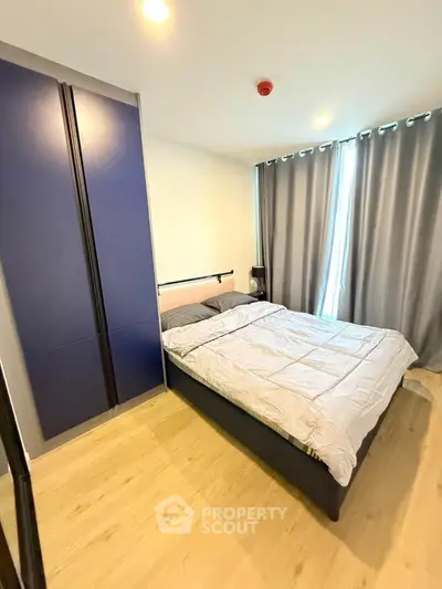 Modern bedroom with stylish blue wardrobe and cozy bed