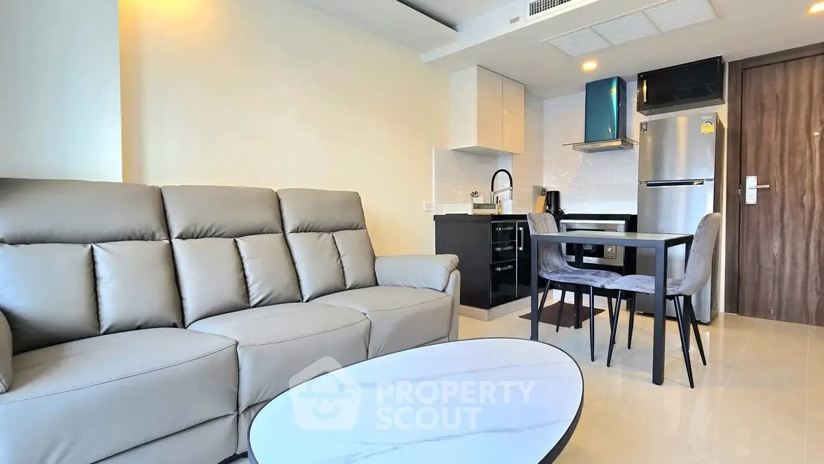 Modern living room with sleek kitchen and stylish furniture in open layout apartment.