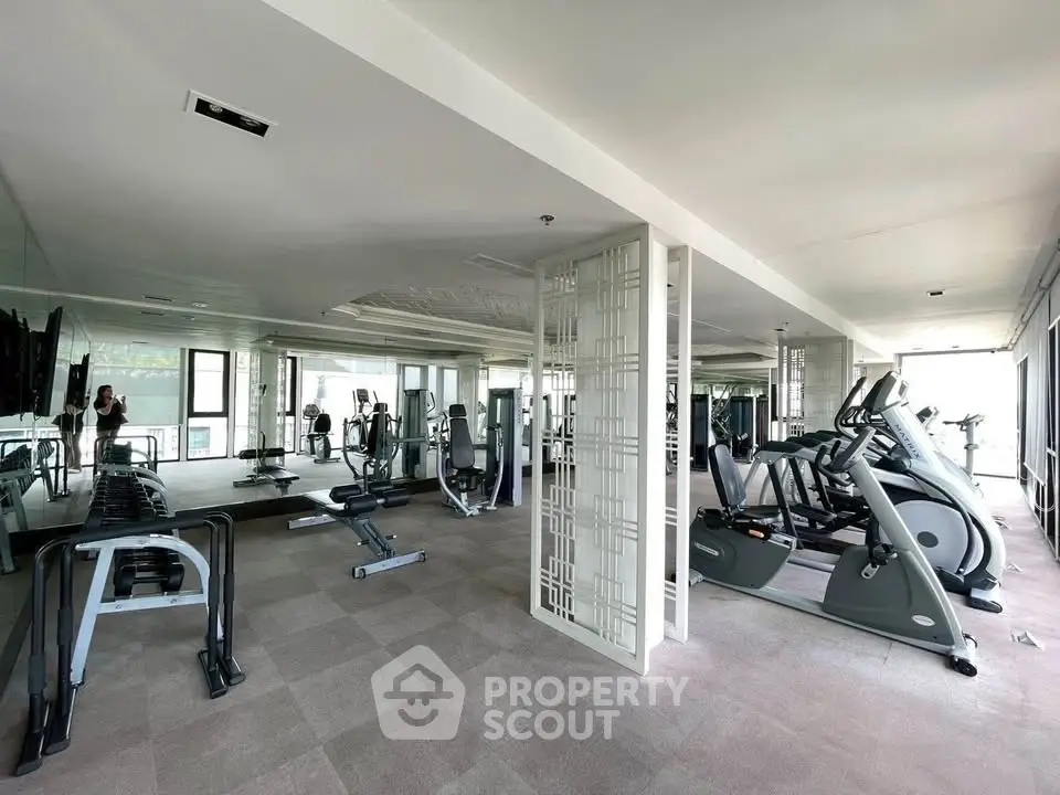 Spacious modern gym with state-of-the-art equipment in luxury residential building.