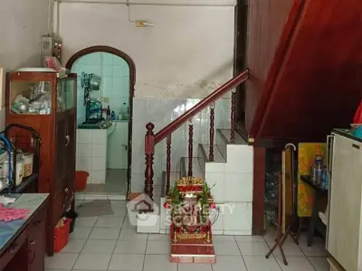 Charming interior with wooden staircase and cozy kitchen in a traditional home setting.