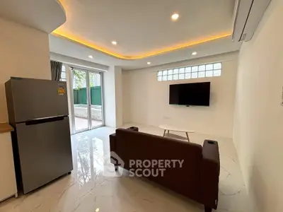 Modern living room with sleek design, featuring a wall-mounted TV and stylish lighting.
