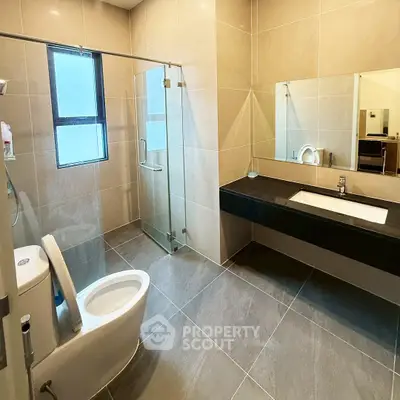 Spacious modern bathroom with glass shower and sleek fixtures
