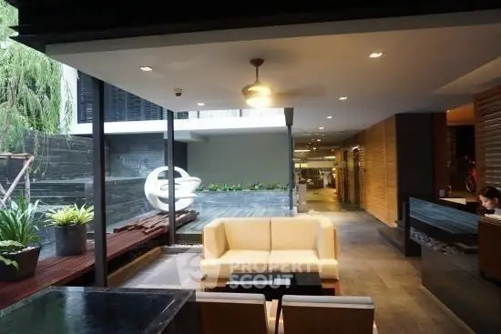 Modern lobby with stylish seating and large windows overlooking a serene outdoor area.