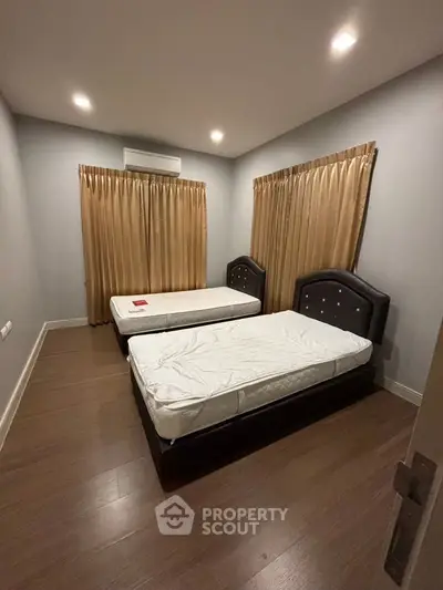 Cozy bedroom with twin beds and elegant curtains, perfect for a restful retreat.
