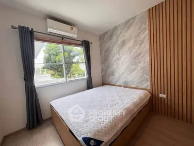 Cozy bedroom with modern design and large window offering natural light.