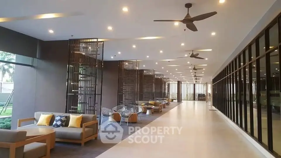 Spacious modern lobby with stylish seating and ceiling fans in a luxury building.