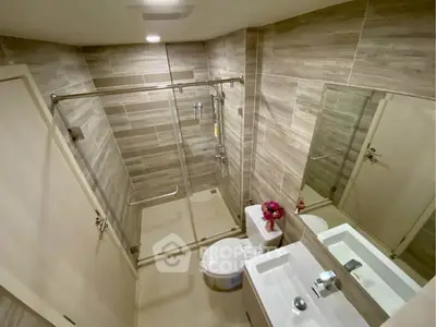 Modern bathroom with glass shower and sleek fixtures in a contemporary apartment.