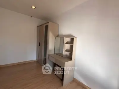Minimalist bedroom with wardrobe and vanity set, perfect for modern living.