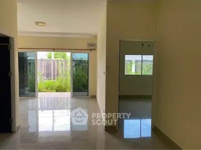 Spacious living room with large windows and garden view, perfect for natural light lovers.