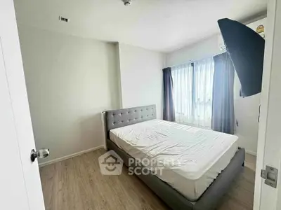 Spacious bedroom with natural light and modern decor, featuring a comfortable bed and elegant curtains.
