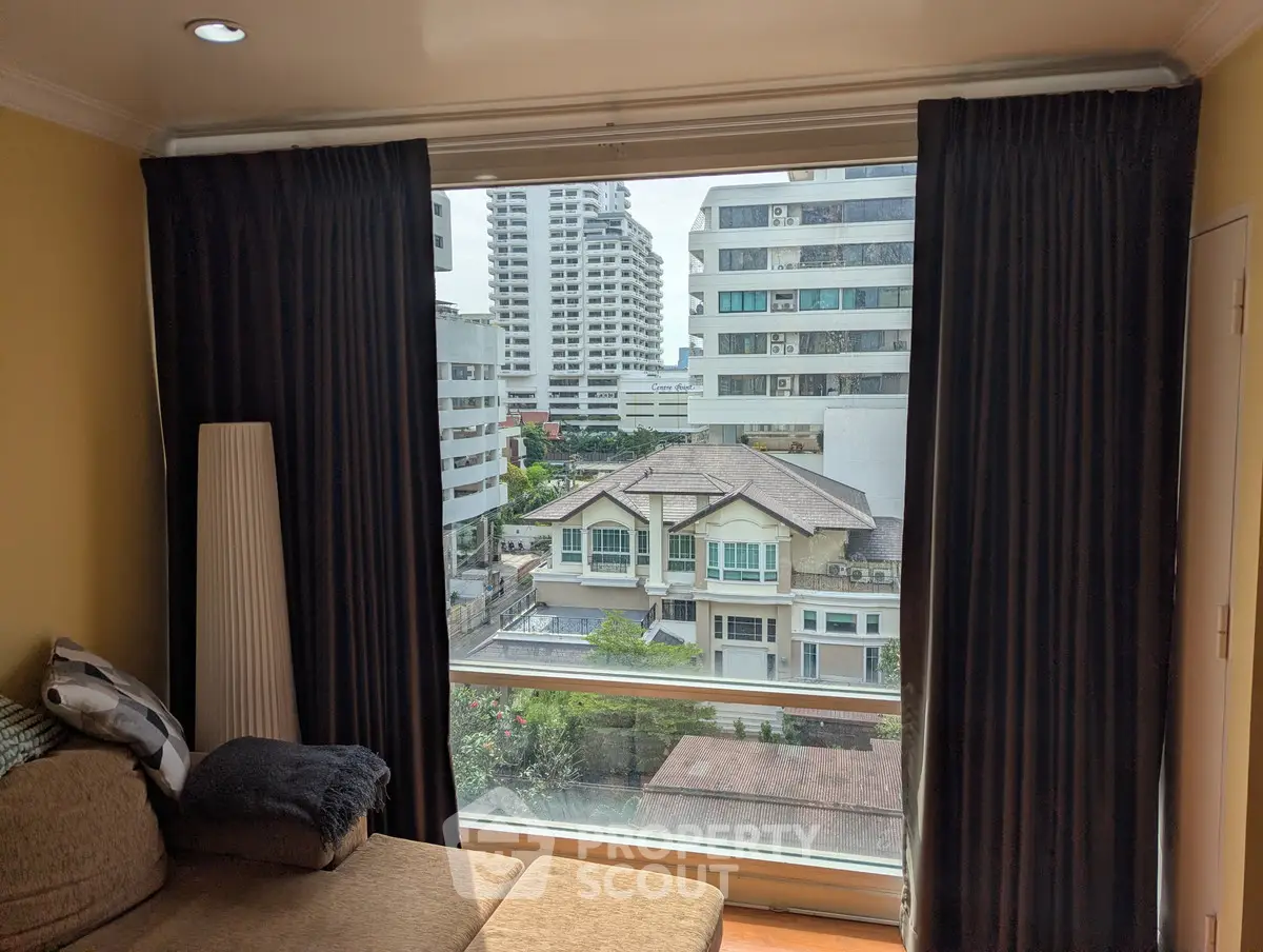 Spacious living room with large window offering stunning city view