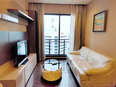 Modern living room with large window and city view, featuring stylish furniture and decor.