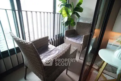 Charming balcony with wicker chairs and lush plant, perfect for relaxation.