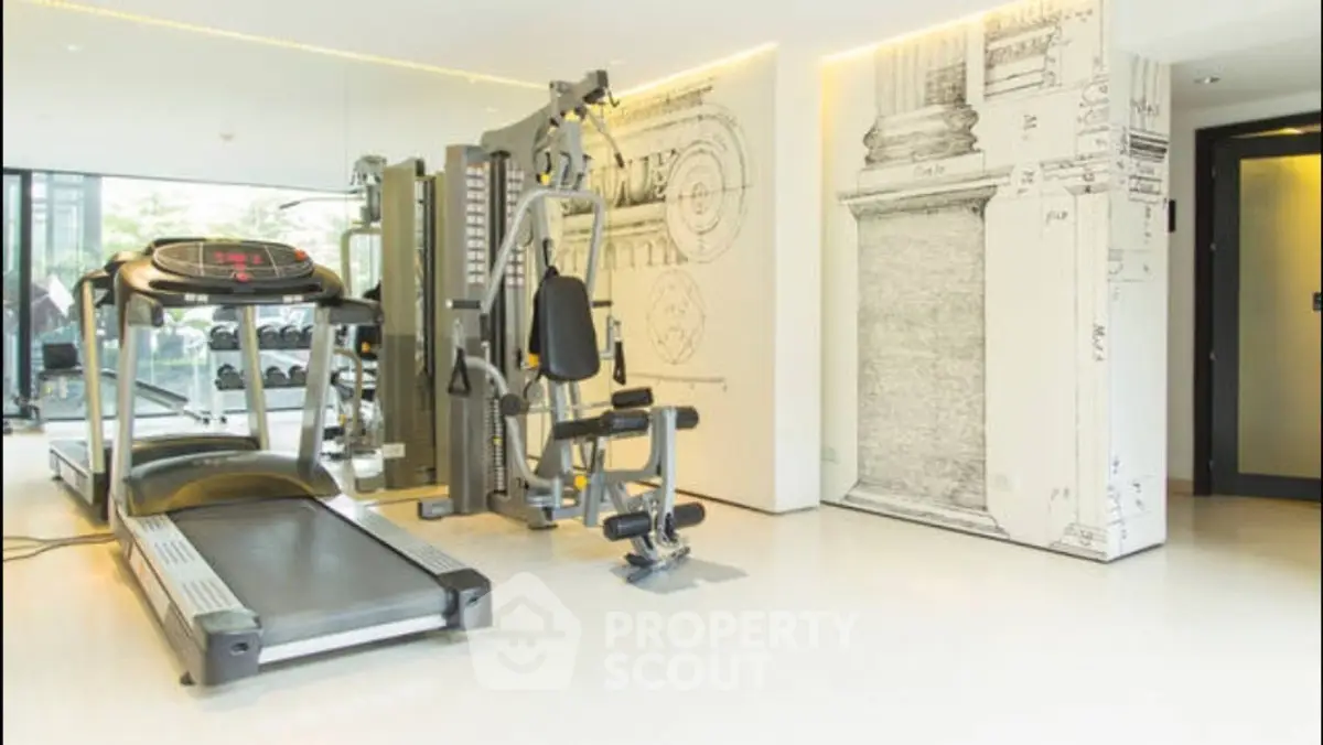Modern gym with state-of-the-art equipment and stylish decor in luxury residential building.