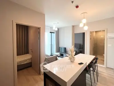 Modern apartment interior with open layout, featuring kitchen island and cozy living area.