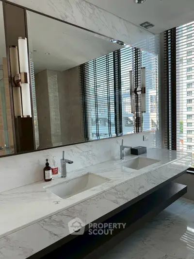 Luxurious modern bathroom with dual sinks and marble finishes in high-rise apartment.