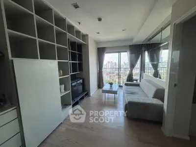 Modern living room with city view, featuring sleek shelving and cozy sofa.