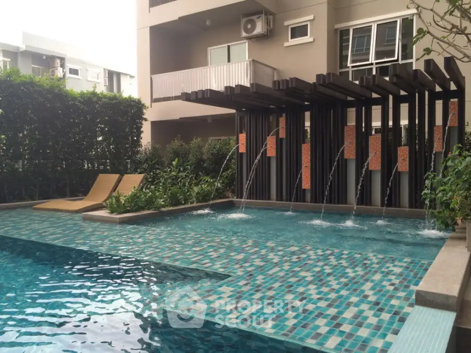 Luxurious apartment pool area with modern design and water features.