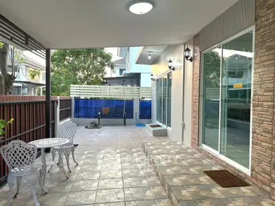 Spacious tiled patio with elegant outdoor seating and modern lighting, perfect for relaxation and entertainment.