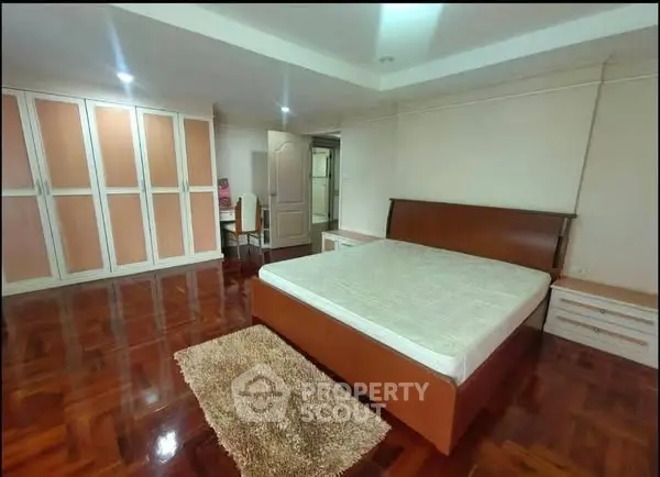 Spacious bedroom with wooden flooring and ample wardrobe space