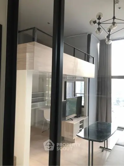 Modern loft apartment with mezzanine, stylish lighting, and large windows offering city views.