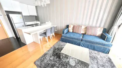 Modern open-layout living room with stylish furniture and kitchen area