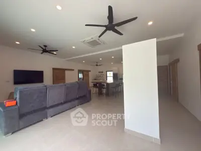 Spacious modern living room with open layout and sleek ceiling fans