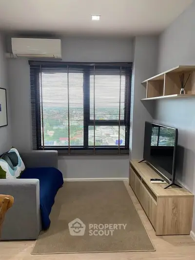 Modern living room with large window and stylish furniture, offering a cozy and inviting atmosphere.