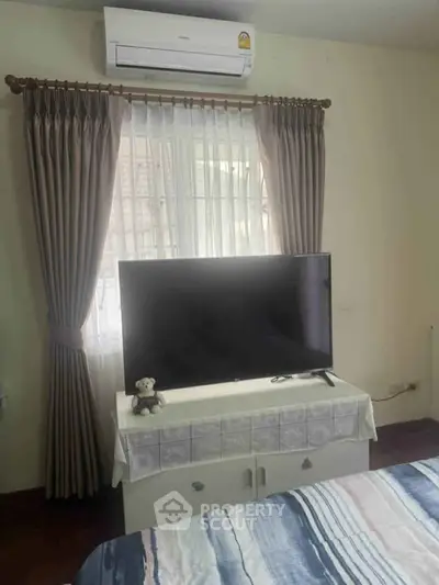 Cozy bedroom with air conditioning and TV, perfect for relaxation.