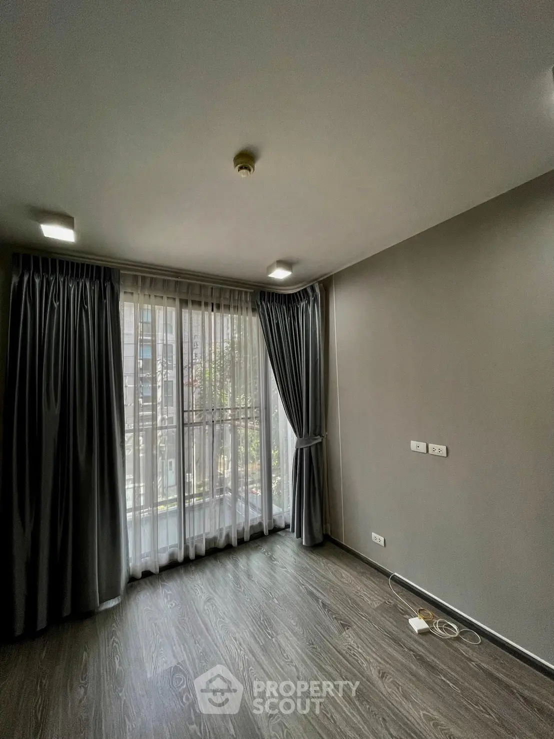 Spacious room with large windows and elegant curtains, perfect for natural light and modern living.
