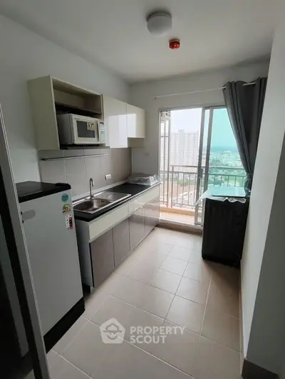 Modern kitchen with balcony view in high-rise apartment
