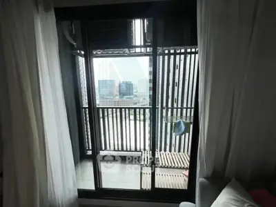 Modern apartment balcony with city view through glass doors, featuring sleek design and cozy ambiance.