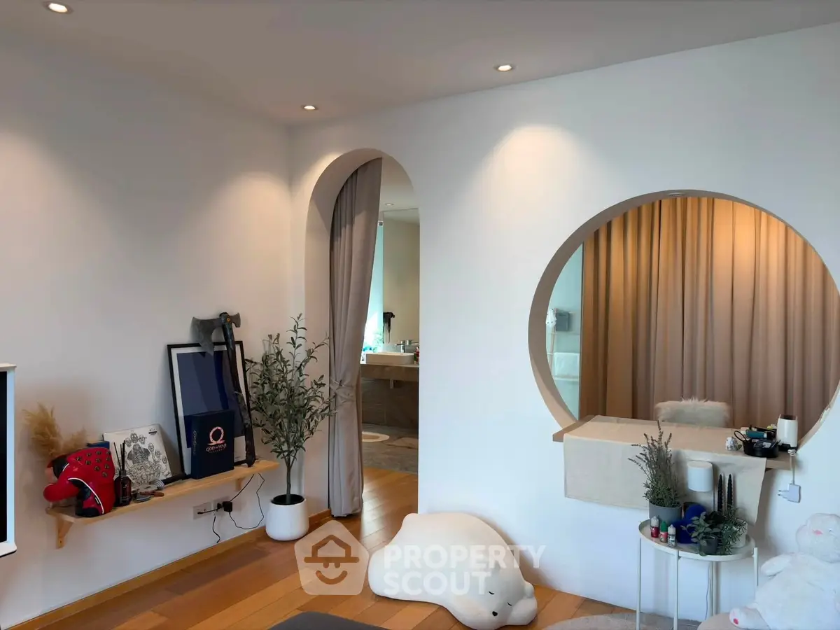 Modern living room with unique circular mirror and cozy decor