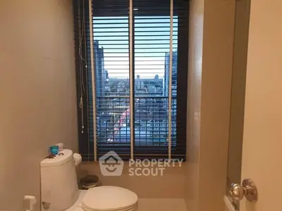 Modern bathroom with city view through large window and sleek blinds.