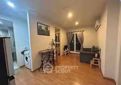 Spacious living room with modern decor and open kitchen layout, featuring hardwood floors and natural light.
