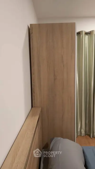 Cozy bedroom corner with wooden headboard and soft curtains