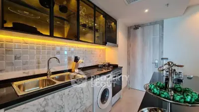 Modern kitchen with marble countertops, washing machine, and sleek cabinetry.