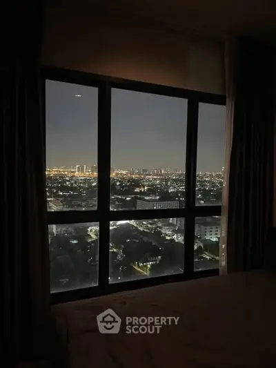 Stunning cityscape view from a high-rise apartment window at night.