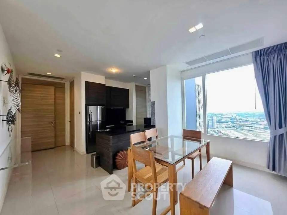 Modern living room with dining area and city view, featuring sleek furniture and large windows.
