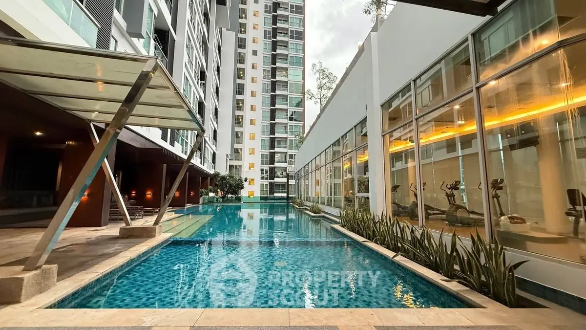 Luxurious modern apartment complex with stunning swimming pool and gym facilities.