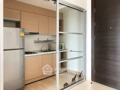 Modern kitchen with sliding glass door and wooden cabinets in a stylish apartment.