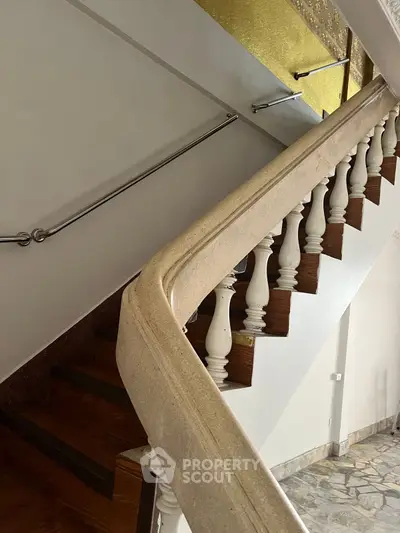 Elegant staircase with wooden steps and ornate railing in a stylish home