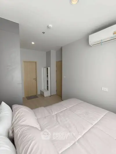 Modern bedroom with minimalist design and air conditioning in a stylish apartment.