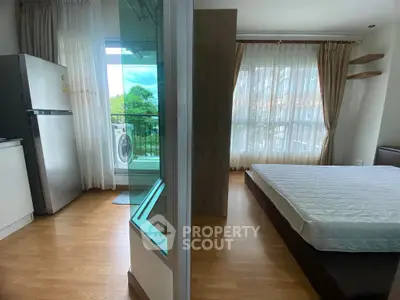Modern apartment with open layout, featuring bedroom and kitchen with balcony view.