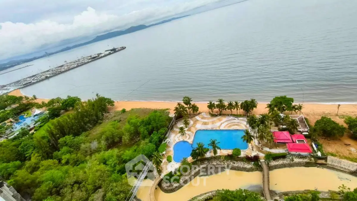 Stunning beachfront property with pool and lush greenery offering panoramic ocean views.