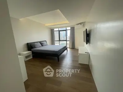 Spacious modern bedroom with city view, featuring sleek design and ample natural light.