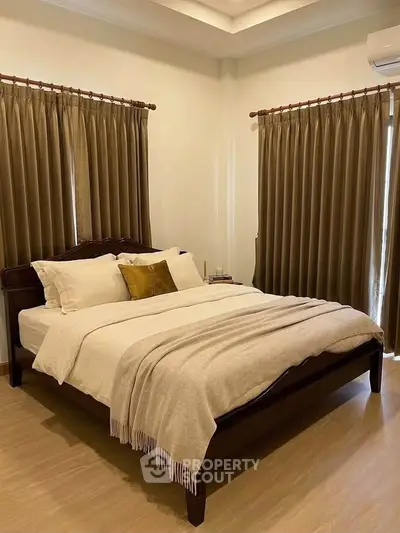 Elegant bedroom with cozy bed, warm lighting, and stylish curtains for a serene ambiance.