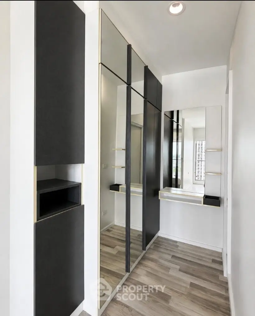 Sleek modern hallway with mirrored closet and stylish flooring in a contemporary apartment.
