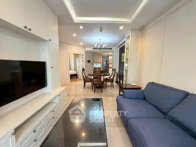 Spacious living room with modern furniture and open dining area in a stylish apartment.